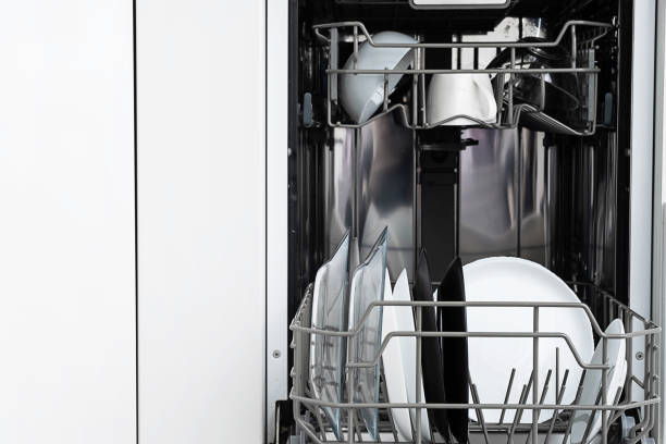 istock Clean plates after washing in dishwasher at home.  Modern kitchen with dishwashing machine. Household equipment. 1357668294
