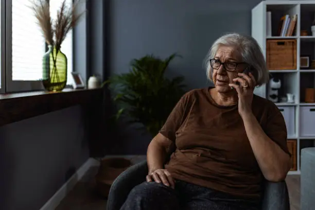 Shot of a senior woman talking on mobile phone while sitting in her room