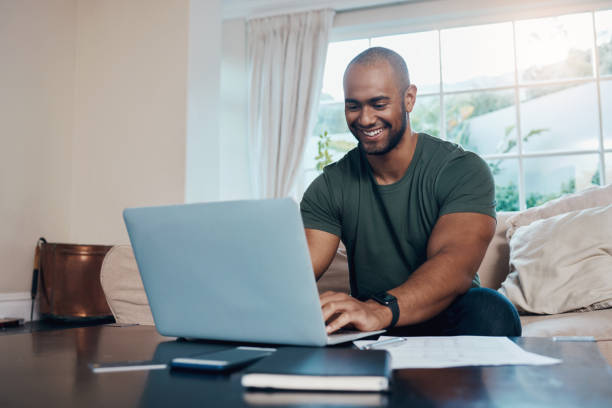 istock Shot of a young man using his laptop while working from home 1357669644