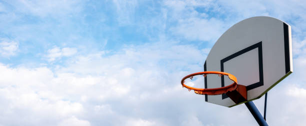 Basketball hoop without a net on cloudy sky simple abstract sport wide blank empty background texture, copy space, wide banner. Sports, leisure activities creative bright backgrounds concept, nobody