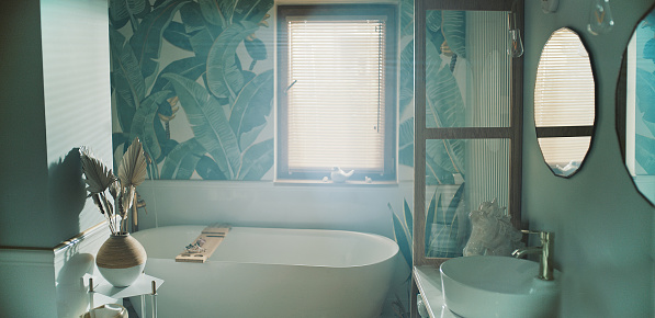 Bathtub surrouded by tropical plants on the the wallpaper. Home SPA