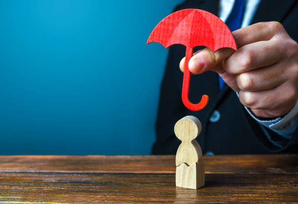 agente de seguros sostiene un paraguas sobre un hombre con una grieta. rehabilitación después de traumatismos, drogas, alcohol. seguro de salud y vida. ayuda psicológica. apoyo social. recuperación. protectorado, mecenazgo - umbrella men business businessman fotografías e imágenes de stock