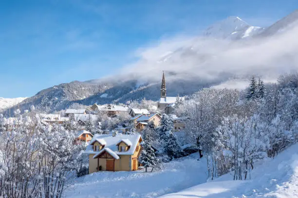 The village of Saint Leger les Melezes in the Champsaur Valley of Hautes-Alpes covered in snow in winter. Ski resort in the Ecrins National Park, French Alps, France