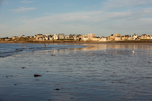 St Malo, France - September 14, 2018: Beach in the evening sun and buildings along the seafront promenade in Saint Malo. Brittany, France