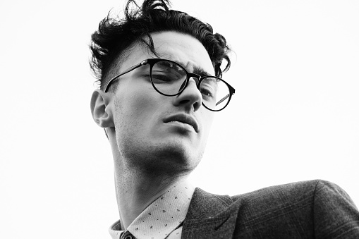 Elegant young handsome man. Outdoors fashion portrait. Man with glasses.Black and white picture.