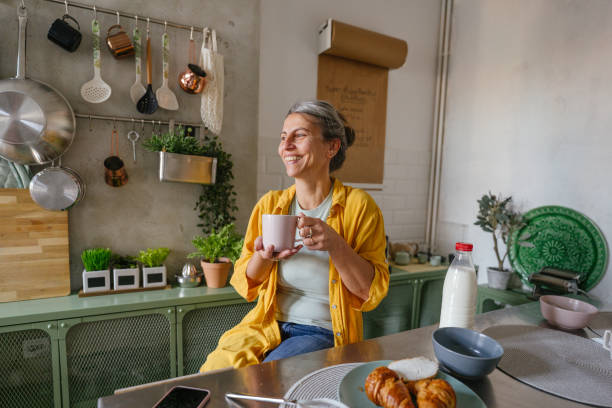 mujer tomando un primer café por la mañana en la cocina - mujer bebiendo leche fotografías e imágenes de stock