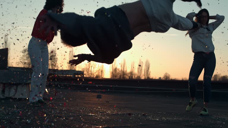 Super slow motion of young man showing breakdance moves while dancing with friends