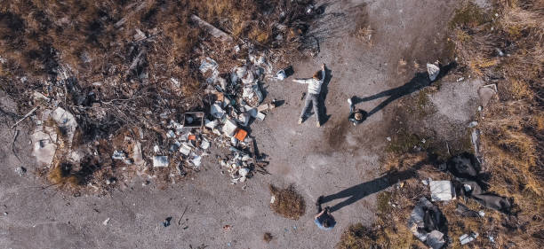 o corpo de uma adolescente assassinada é examinado por um perito encontrado usando um drone em um depósito de lixo durante a fotografia aérea para procurar pessoas desaparecidas, exame forense - rescue mountain horizontal three people - fotografias e filmes do acervo