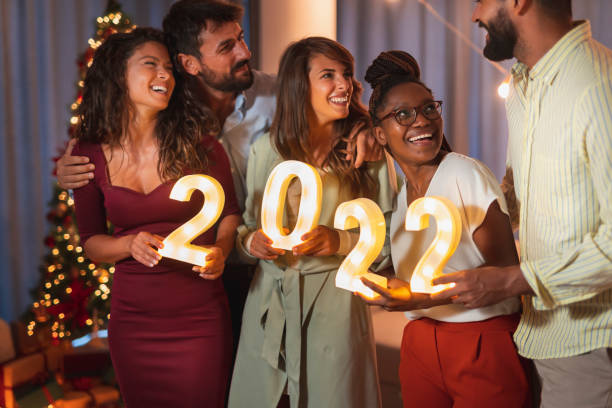istock Friends holding illuminative numbers 2022 while celebrating New Year 1357679789