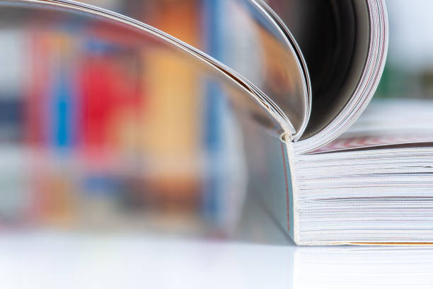 istock Open book with blur bookshelves in background 1357680846