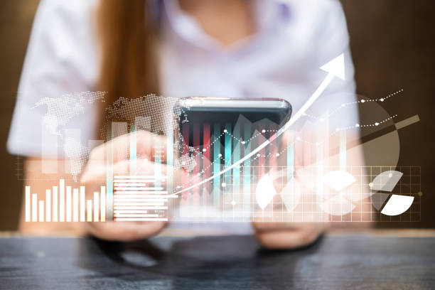 istock Businesswoman or stock trader analyzing stock graph chart using smartphone with touch screen to buy or sell stock 1357685122