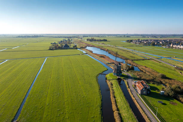 istock Typical Dutch polder landscape with windmill and dutch village 1357686059