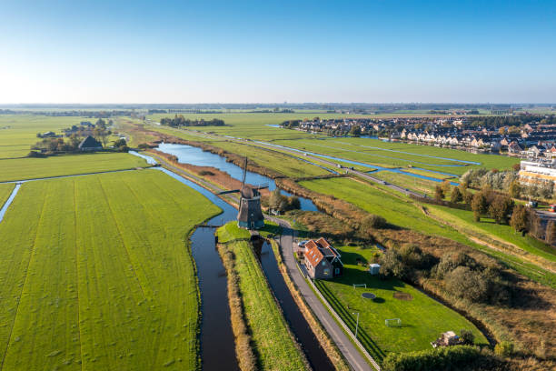 typical dutch polder landscape with windmill and dutch village - polder windmill space landscape imagens e fotografias de stock