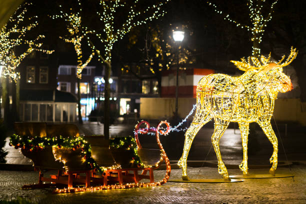 Christmas light moose decorations in front of city hall in Zwolle with snow during a cold winter night