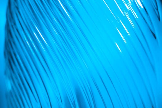 istock Ribbed glass with wavy pattern illuminated in blue light. Creating volume with light. Abstract background with copy space 1357690234