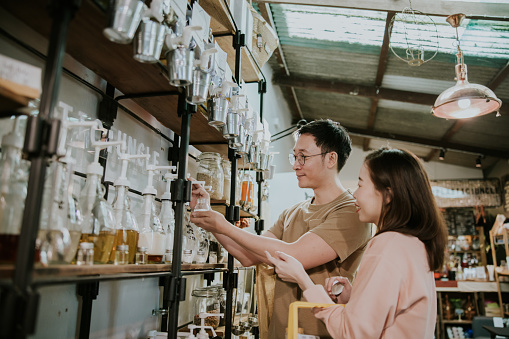 Asian customer couple refill shampoo while shopping in Sustainable Plastic Free Grocery Store