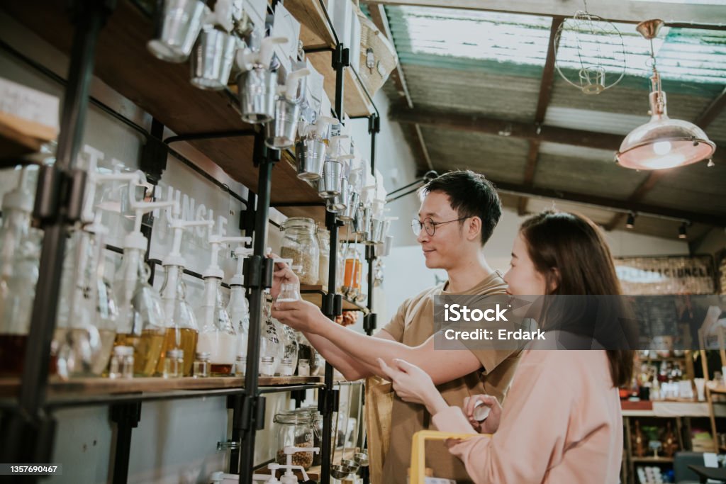 We want to refill the shampoo for tasting while shopping in Sustainable Plastic Free Grocery Store-stock photo Asian customer couple refill shampoo while shopping in Sustainable Plastic Free Grocery Store Zero Waste Stock Photo