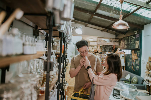 Asian Woman measuring lotion in plastic-free store-stock photo Asian young couple smelling the new body lotion in Sustainable Plastic Free Grocery Store, alternative lifestyle. local products stock pictures, royalty-free photos & images