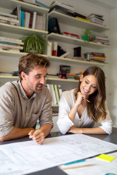 istock Team of happy successful architects working on construction plans in office. 1357691799