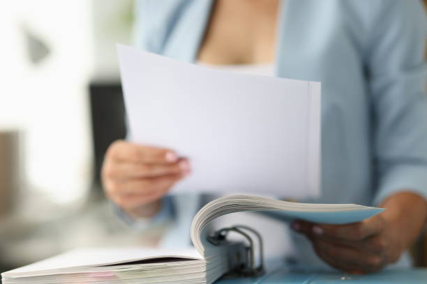 istock Business woman in suit looking documents from folder closeup 1357693461