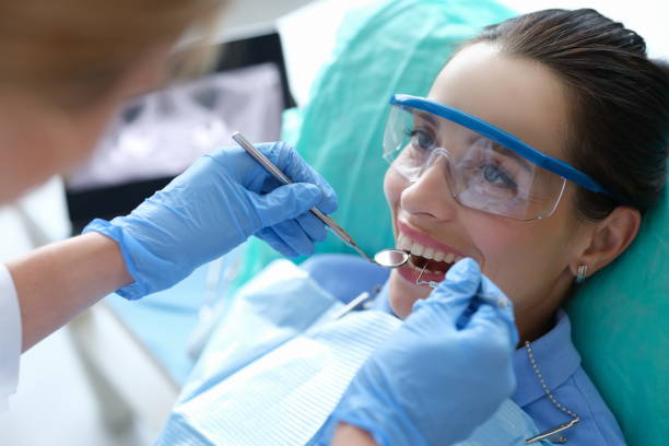 arzt untersucht mundhöhle einer patientin mit zahnärztlichen instrumenten in der klinik - dental cosmetic stock-fotos und bilder