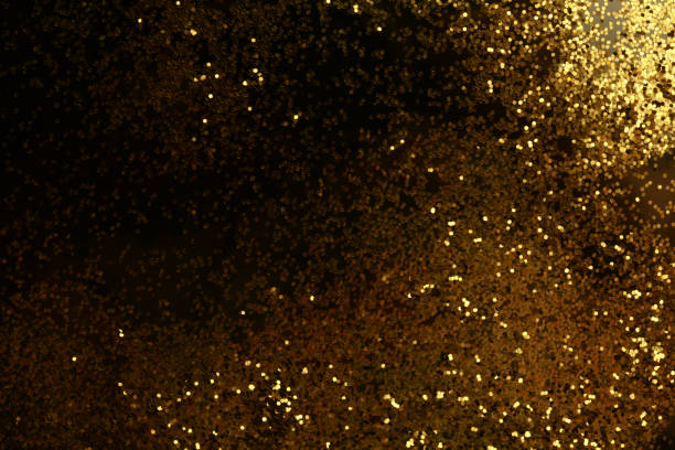 istock Gold (bronze) glitter shine dots confetti on black. Abstract light blink sparkle horizontal backgound. 1357696274