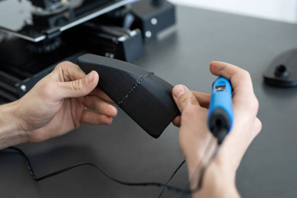 istock Man connects two 3D printer parts with a 3D pen 1357698563