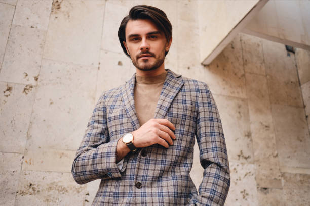 istock Young handsome man in stylish checkered jacket confidently looking in camera outdoor 1357709713