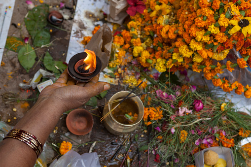 Close up photo of Indian human hand devoting puja to god while praying. Shot under daylight.