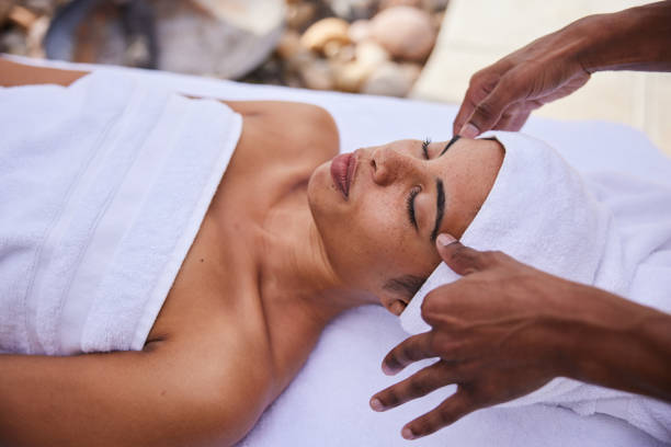 istock Woman lying on a spa table wrapped in towels and getting a head massage 1357711434