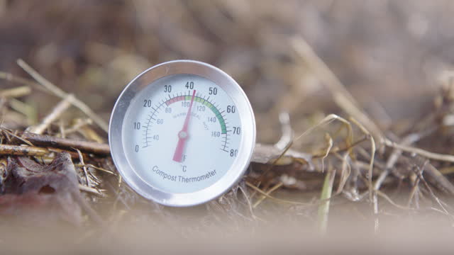 SLOW MOTION CU ZOOM IN - steam rises around the compost thermometer. Ideal temp