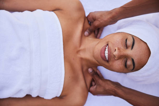 istock Smiling woman lying on a table spa table getting a shoulder massage 1357713243