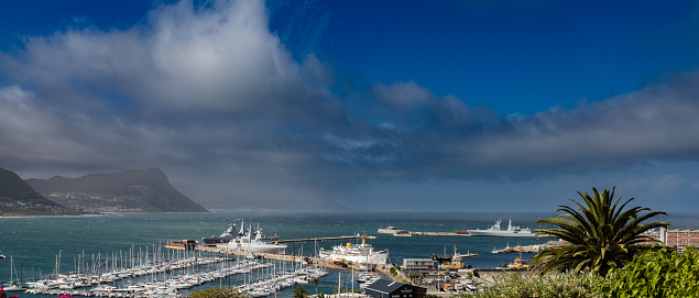 Three frigates of the South African navy, and other ships, moored in the harbour at Simonstown in False Bay, near Cape Town, on a sunny afternoon.