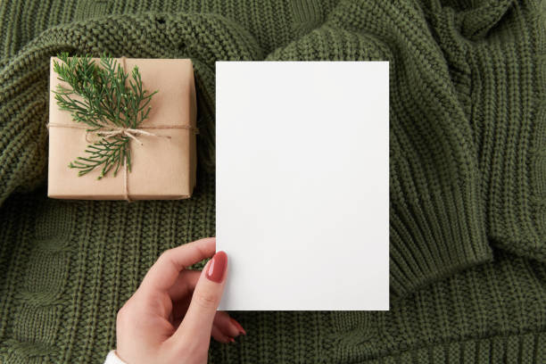 istock Vertical card mockup with green knitted sweater background 5x7 intivation template 1357721250