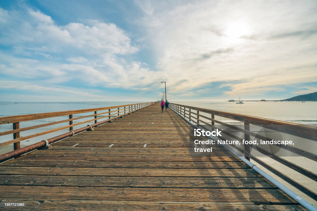 Large longue jetée en bois sur la plage avec un beau ciel nuageux en arrière-plan, côte californienne - Photo de Avila Beach - California libre de droits