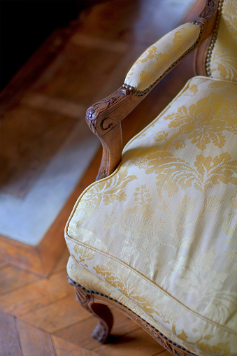 Close up of a classic wooden armchair and floor on background