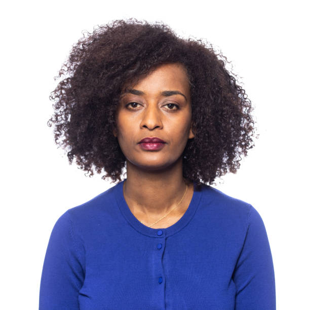 studioporträt auf weiß einer farbigen frau mit afro-haar - women african descent serious human face stock-fotos und bilder