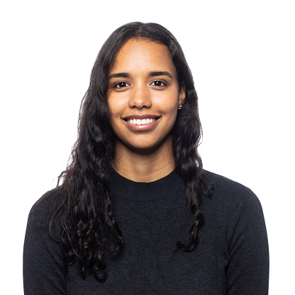 Friendly cheerful young woman of latin american ethnicity being photographed in a photo studio on white background