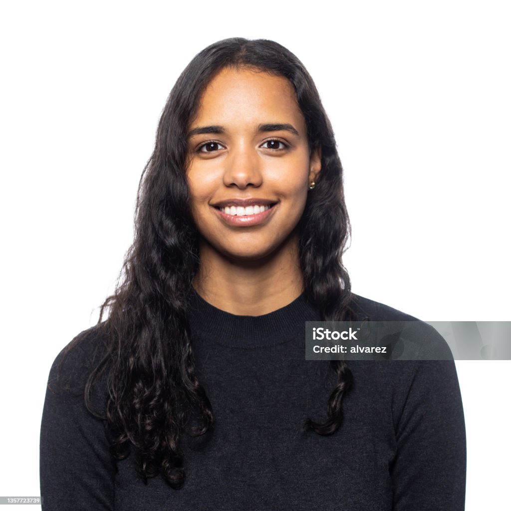 Studio portrait of a smiling young latin woman Friendly cheerful young woman of latin american ethnicity being photographed in a photo studio on white background Portrait Stock Photo