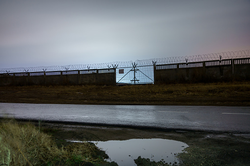 Protected area fence with barbed wire in the dark of night. Background with copy space for text