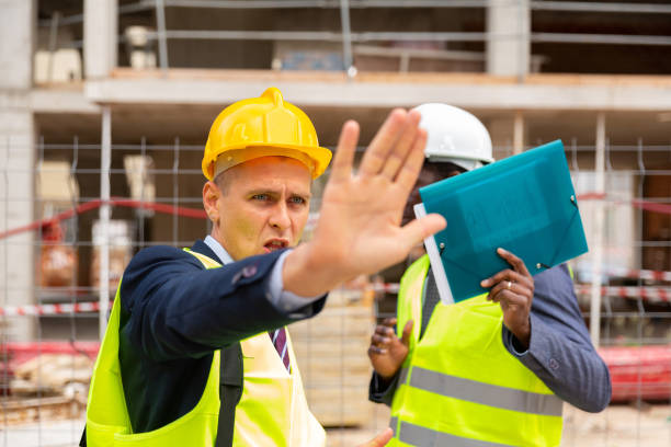 istock Foreman prohibits photographing on the construction site, closing camera lens 1357724827