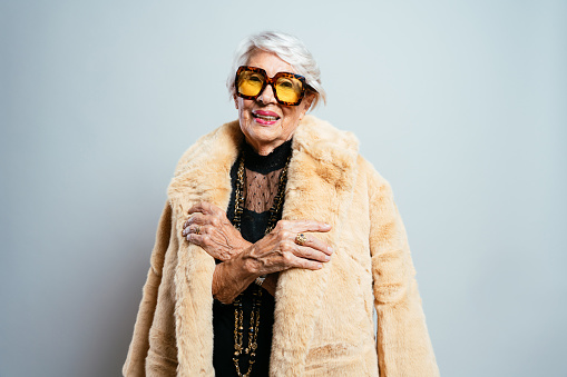 Portrait of an elderly transgender lady wearing a colorful dress.