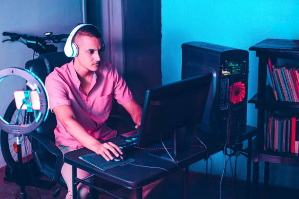 istock young latinx gamer man with headsets playing games on a computer. 1357726134