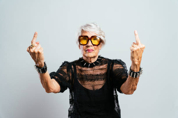 image of a beautiful and elegant old woman Beautiful and elegant old influencer woman. Cool grandmother posing in studio wearing fashionable clothes. Happy senior lady celebrating and making party. Concept about seniority and lifestyle insurrection stock pictures, royalty-free photos & images