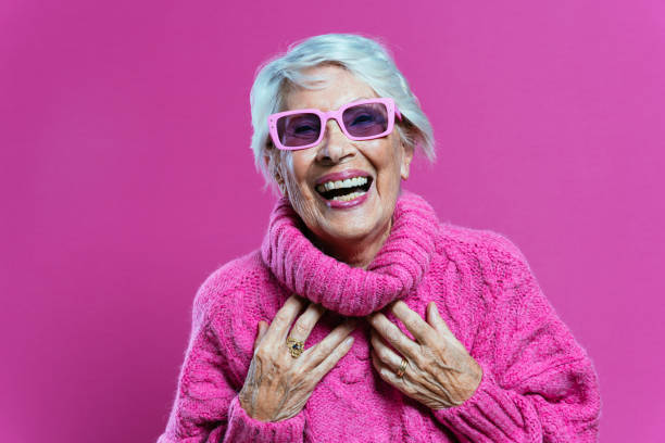 image of a beautiful and elegant old influencer woman. Cool grandmother posing in studio wearing fashionable clothes. Happy senior lady celebrating and making party. Concept about seniority and lifestyle