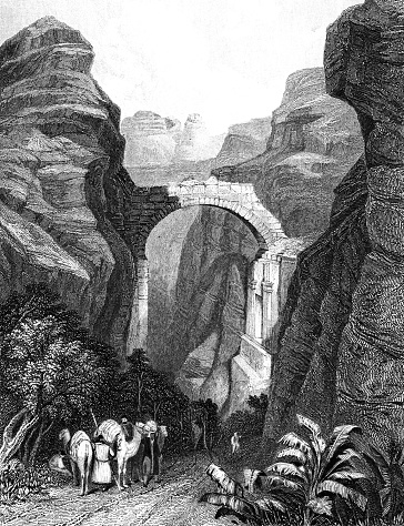 The Triumphal Arch over the Siq at ancient city of Petra in Jordan. Vintage etching circa 19th century. The arch was destroyed in 1896 from an earthquake and only small remnants remain.