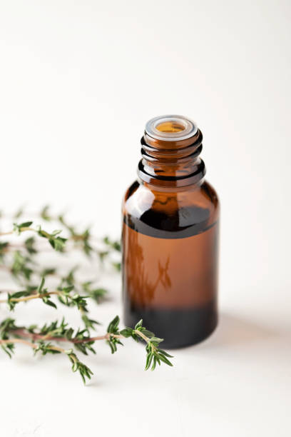 istock Thyme essential oil in a glass bottle close-up on a light background. Thyme branches are on the table. 1357729191