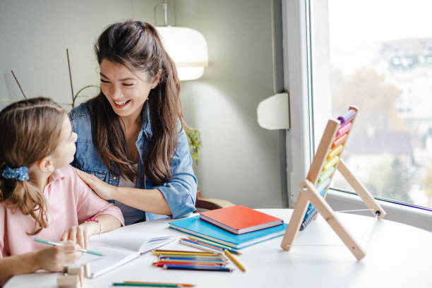 istock Young mother helps her daughter to finish homework 1357729808