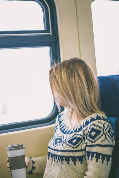 istock Woman in the train looking through the window 1357730462