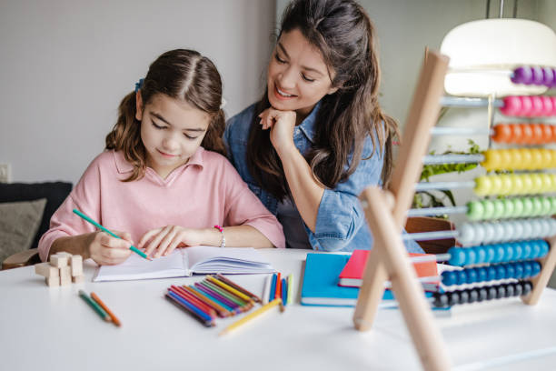 istock Young mother helps her daughter to finish homework 1357730568